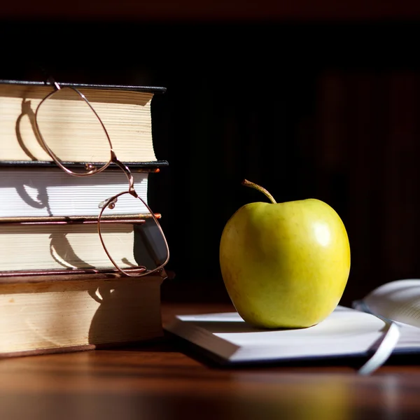 Grönt äpple på öppna boken — Stockfoto