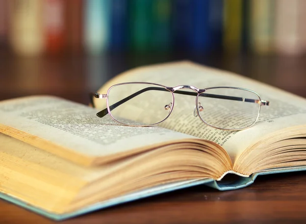 Bicchieri e libro in biblioteca — Foto Stock