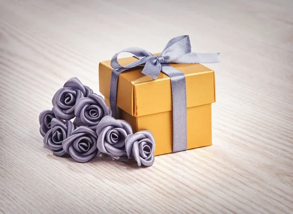 Grey flowers and golden gift box — Stock Photo, Image
