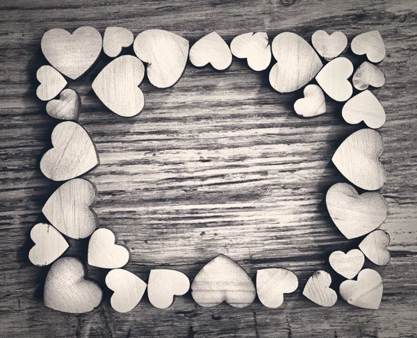 Frame with hearts on a wooden background — Stock Photo, Image