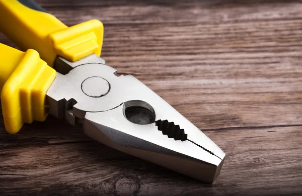 Ahşap arka plan üzerinde multitool pense — Stok fotoğraf