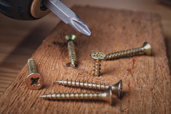 Tornillo que se atornilla en un pedazo de madera —  Fotos de Stock