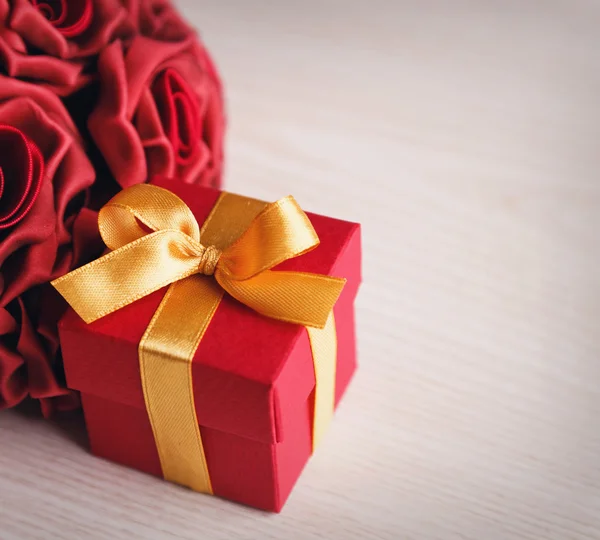Красные цветы и подарочная коробка — стоковое фото