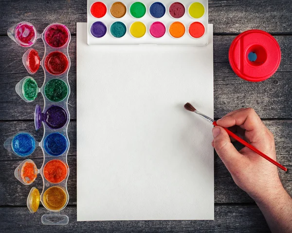 Hand with brush painting with watercolor — Stock Photo, Image