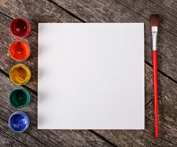 Pinturas para pintura y pincel con hoja de papel blanco en blanco — Foto de Stock