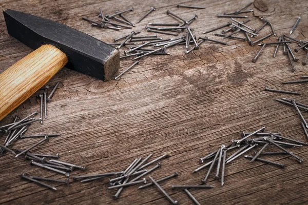 Martillo de metal y clavos en tablero de madera — Foto de Stock