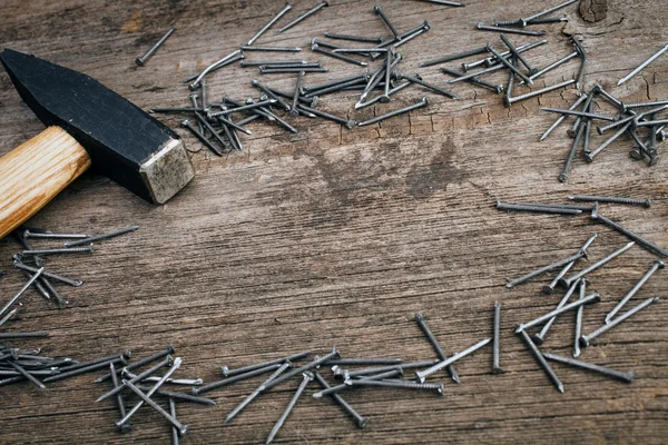 Martillo de metal y clavos en tablero de madera — Foto de Stock