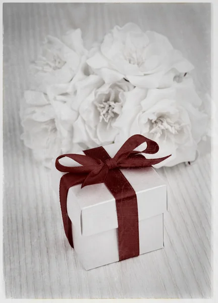 Witte bloemen en cadeau doos met rood lint — Stockfoto