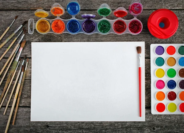 Set vernici ad acquerello con pennelli e foglio di carta — Foto Stock