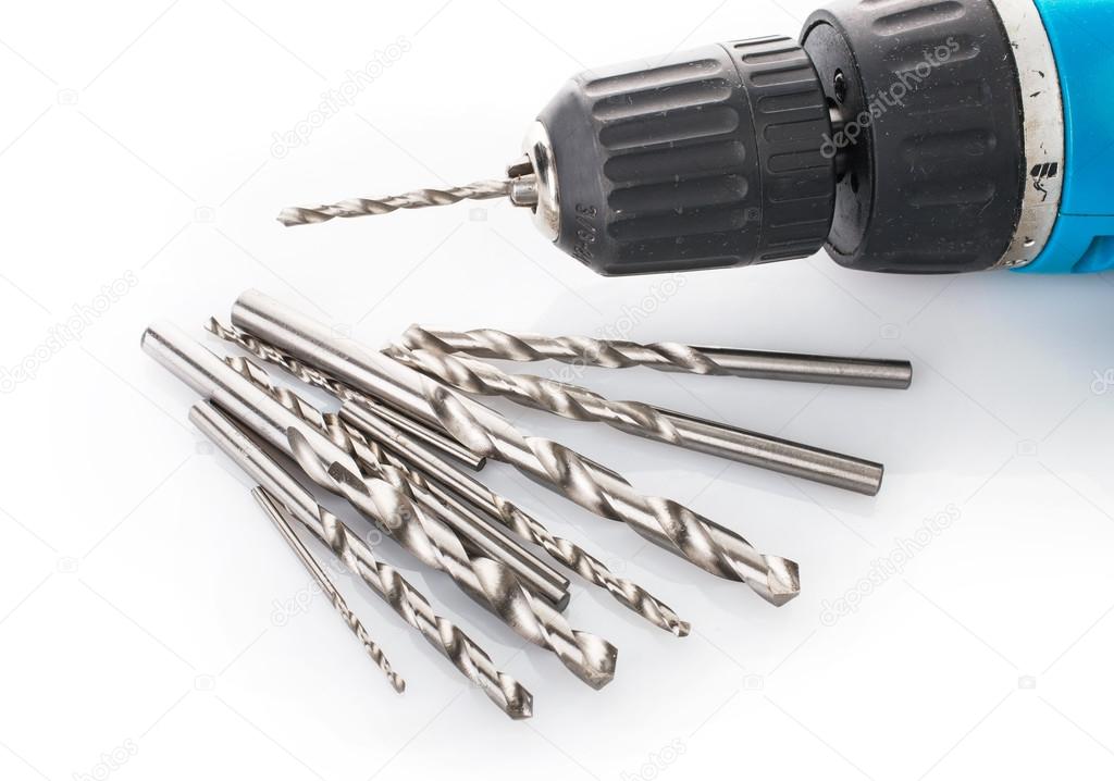 Drill and set of drill bits on white