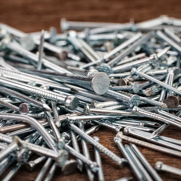 Iron nails on wooden background — Stock Photo, Image