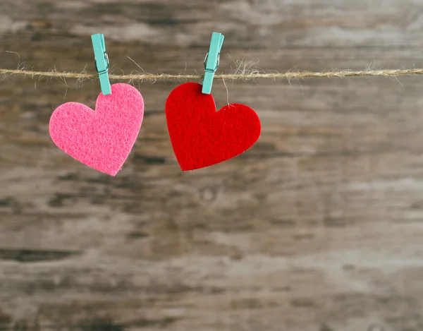 Två röda och rosa hjärtan som hänger på en sladd — Stockfoto