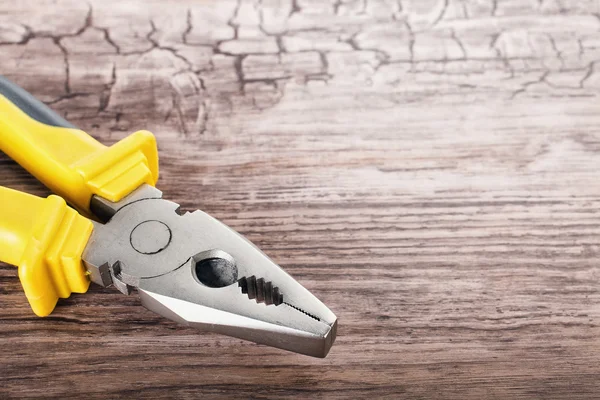 Ahşap arka plan üzerinde multitool pense — Stok fotoğraf