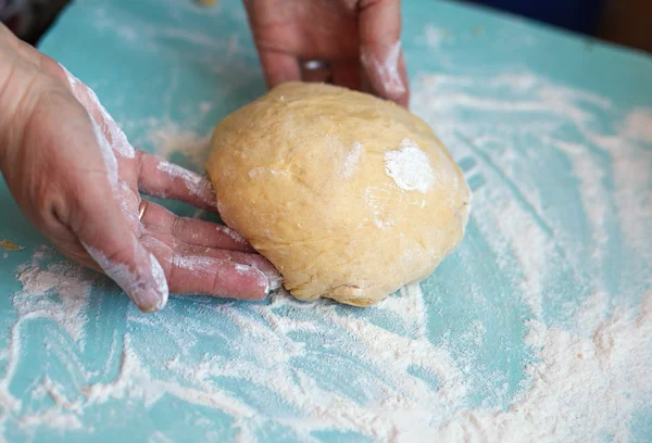 Жінки руки замішують тісто на столі — стокове фото