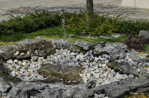 Small water fountain flowing from stone bed — Stock Photo, Image