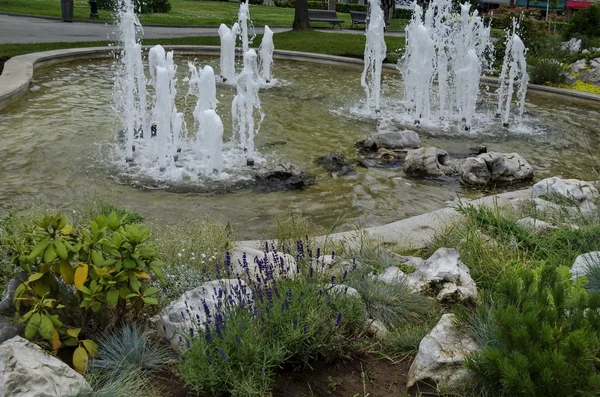 Grupo de pequeñas fuentes de agua que fluyen en frente de belleza rocosa , — Foto de Stock