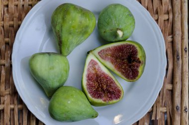 Sofya ve Bulgaristan 'da beyaz bir tabakta tam ve iki yarım incir.  