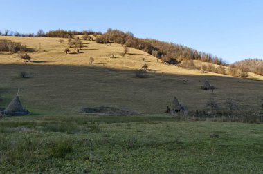 Bulgaristan 'ın Vasiliovo, Teteven kasabası yakınlarında kış için geleneksel saman kaseleriyle bir dağ çayırı manzarası  