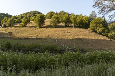 Bulgaristan 'ın Vasilyovo kasabası yakınlarında kış, orman ve sebze bahçesi için geleneksel samanlı bir dağ çayırı manzarası  