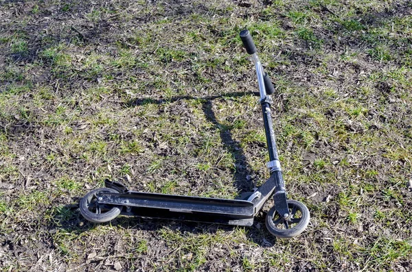 Kids scooter parked at field — Stock Photo, Image