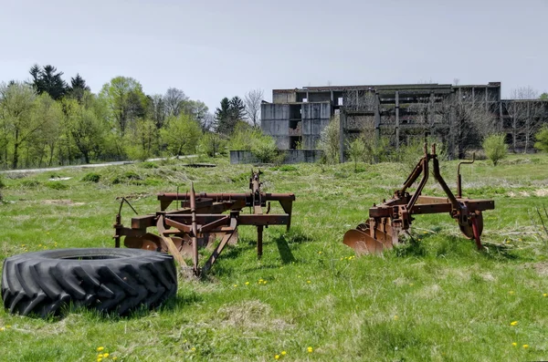 Verlaten van de onvoltooide gebouw en boerderij machines — Stockfoto