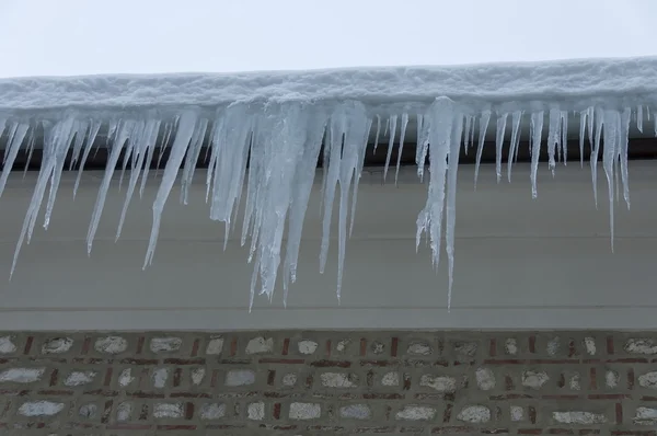 Eiszapfen von einem schneebedeckten Dach im Winter in Bansko — Stockfoto