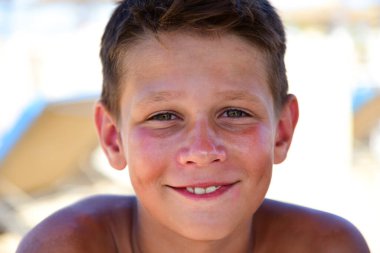 Kumsalda bronzlaşmış bir gencin portresi..