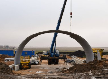 İnşaat makineleri yolun altına bir tünel inşa ediyor..