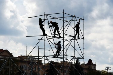 İnşaatçılar, metal bir çerçeveden şehirde bir sahne oluşturuyorlar..