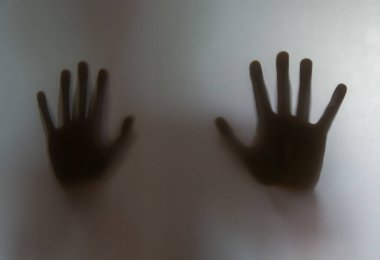 Çocukların gölgelerinin yansıması. Elleri buzlu camda, bulanık..