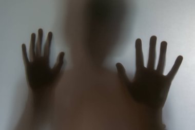 Çocukların gölgelerinin yansıması. Elleri buzlu camda, bulanık..