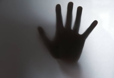 Çocukların gölgelerinin yansıması. Elleri buzlu camda, bulanık..