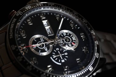 Siyah arkaplanda lüks kuvars kronograf saati, yakın plan..