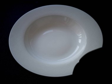 Siyah arkaplanı olan beyaz seramik tabak