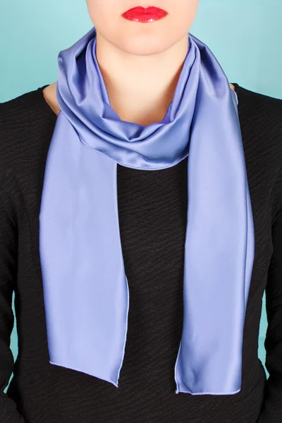 真丝围巾。在蓝色背景上孤立她脖子上的蓝色丝绸围巾. — 图库照片