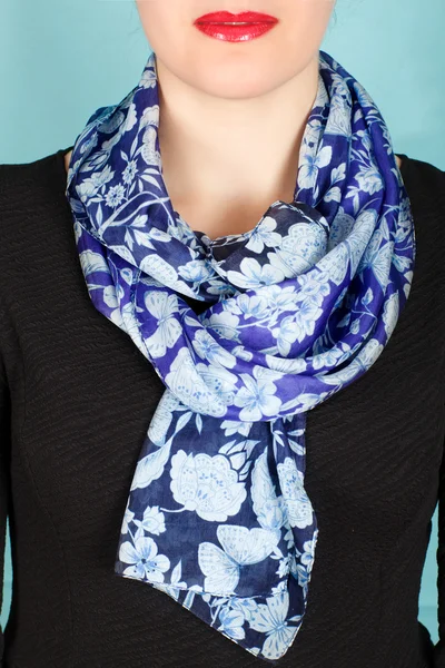 Silk scarf. Blue silk scarf around her neck isolated on blue background.
