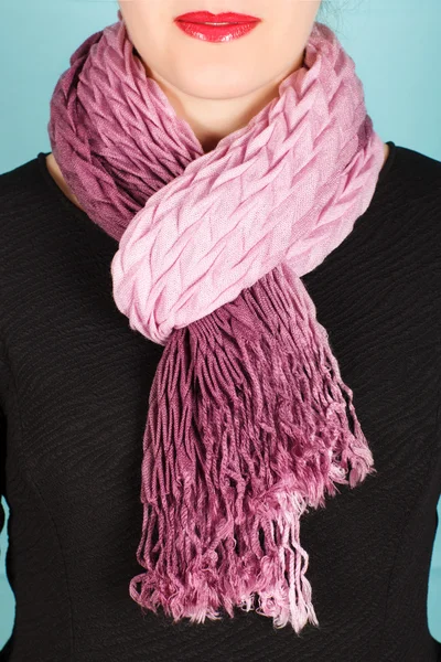 Silk scarf. Pink silk scarf around her neck isolated on blue background.