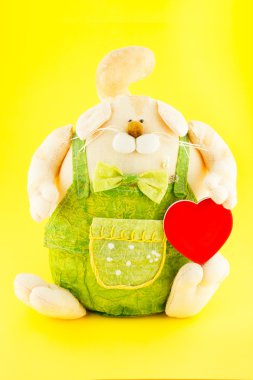 yumuşak oyuncak. tavşan tulumlu altın oyuncak kalp ile onun elinde giyinmiş.