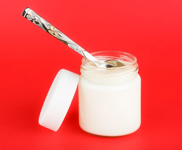 Jar with yogurt isolated on red background — Stock Photo, Image