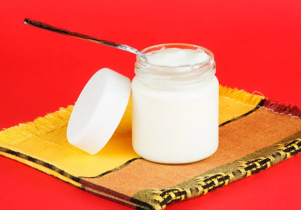 Jar with yogurt isolated on red background — Stock Photo, Image