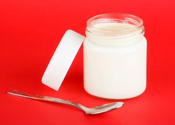 Jar with yogurt isolated on red background — Stock Photo, Image