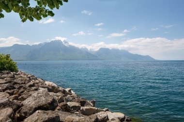 Manzara. Kıyı Gölü ve kar dağlar güneşli bir günde şapkalı.