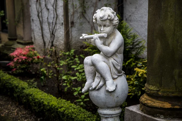 Estatua de Cupido tocando la flauta — Foto de Stock