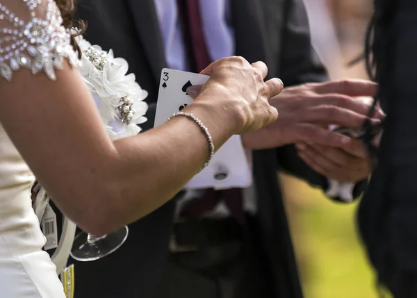 Braut wählt eine Karte von einem Zauberer auf einer Hochzeit — Stockfoto