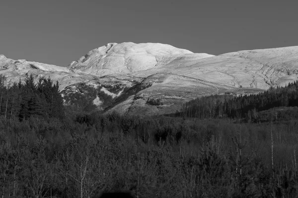 Montagna innevata in bianco e nero in una giornata di sole — Foto Stock