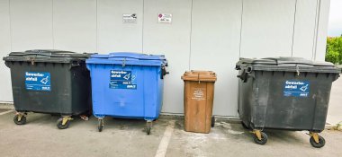 Berlin, Almanya - 18 Mayıs 2025: Geri dönüşüm ve çöp öğütme için kentsel bir alana üç atık kutusu yerleştirildi.