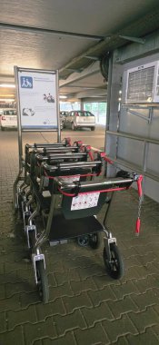 Belin, Almanya - 30 Mayıs 2025: Erişilebilir alışveriş arabaları kolay erişim için bir otoparkta düzgün bir şekilde düzenlenmiştir. Hastane