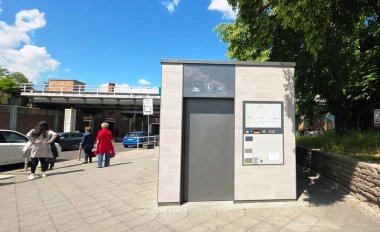 Berlin, Almanya - 26 Mayıs 2025: Modern tuvalet tesisi açık bir tabela içeriyor ve kentsel bir çevrede yer alıyor.