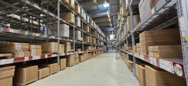 Berlin, Almanya - 05 Mayıs 2025: Depo içi raflarda ve geniş koridorlarda düzgünce istiflenmiş kutular.