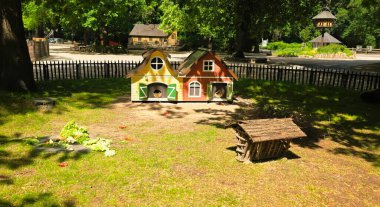 Berlin, Almanya - 22 Mayıs 2025: Renkli hayvan evleri yeşil çimenler ve ağaçlarla çevrili güneşli bir parkta yer almaktadır.